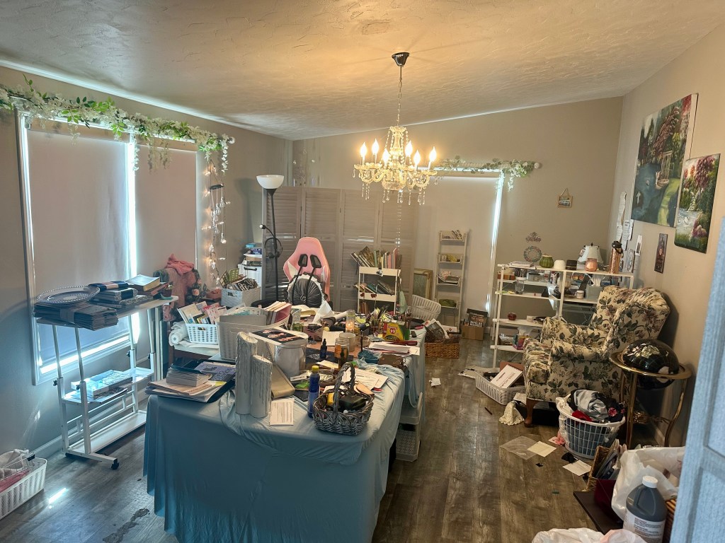 Multipurpose workspace before editing, with furniture, files and project materials limiting usable work and floor space.