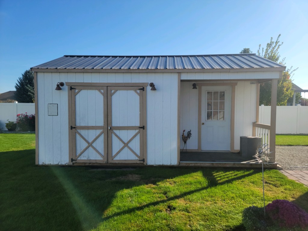 Garden shed before editing, showing accumulated gardening supplies, tools and equipment throughout the interior.