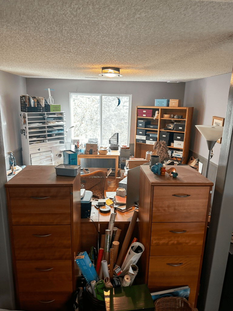 416305949_122136837260070980_9084111237844308841_n Craft room before editing, with filing cabinets and stored supplies crowding the entrance and limiting access to the workspace.